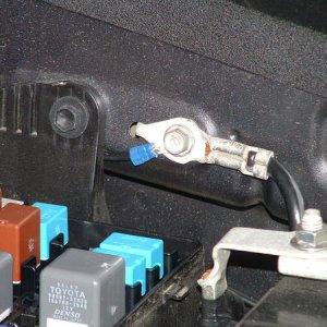 Black (ground) cable fastened to chassis ground cable behind fuse box