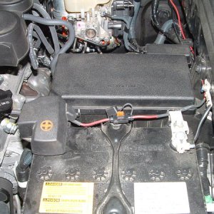 Inline fuse holder fastened to positive battery post and running between battery and fuse box