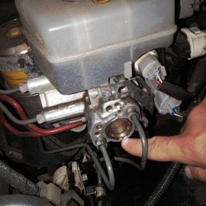 The connector that is just above the knuckle (with the 2, green and white wires). Not the connector directly below the reservoir, but the one below TH
