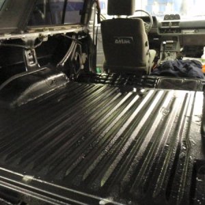 After I threw fiberglass on top of the patched areas, I scuffed and cleaned the whole floor, coated the patched areas and fender wells with POR-15, th