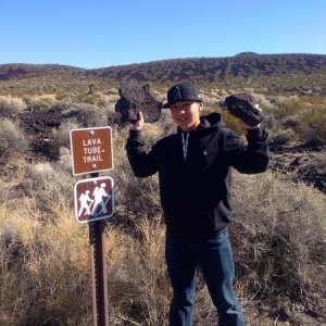My brother holding some lava rocks at the lava tubes we visited