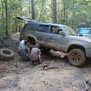 trying to pull out the broken exhaust from rear...had to take off tire for clearance (not sure what the chainsaw was for)