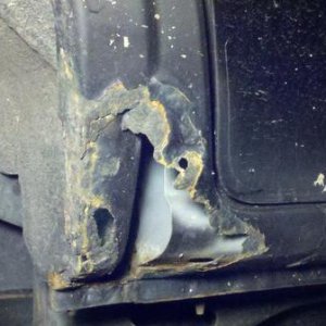 In front of rear pass. wheel well. A piece of plastic was covering this before on both sides. Going to mat & resin.