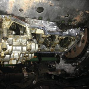 Underside of a Sentra with oil pan off (to remove timing cover (to remove head (to repair leak)))