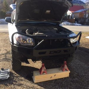 bumper very precariously held in place with some jackstands and the ramps piled on top of eachother.   I had to do the install myself, so I got my wor