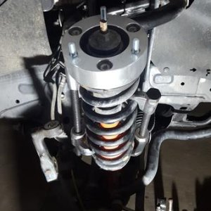 Strut - compressed the spring with the X-REAS lines attached and rotated top hat after installing the spacer. Bolts right up.
