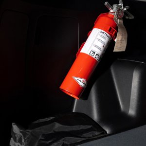 Fire Extinguisher with bracket secured to plastic interior on driver's side using well nuts