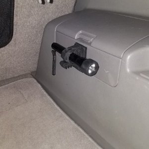 Quick Fist Clamp/ Amazon purchase
Small Maglite mount/industrial strength velcro.  Super strong and no need to make holes in the plastic panels.