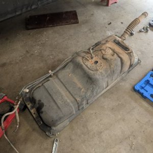 PO decided for whatever reason that instead of dropping the tank, they would take some tin snips to the floorboard and toss the plastic cap while they