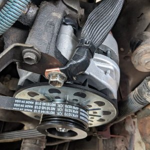 Closeup of the alternator, engine block ground (goes directly to battery negative terminal), and the power steering pump belt used in place of the fac
