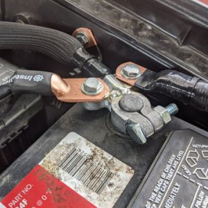 View of the negative battery terminal with the factory ground and battery negative to chassis wires bolted on either side. I also removed the paint wh