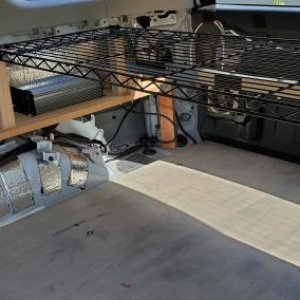 4Runner shelf - passenger side. Two oak legs support the black wire shelf, similar to the driver's side. A Giandel 1200W pure sine wave inverter is bo