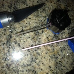 Top needle is with orange paint scraped off

Bottom needle is the stock orange needle