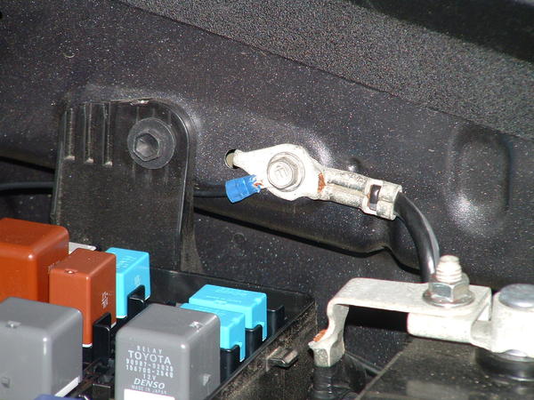 Black (ground) cable fastened to chassis ground cable behind fuse box