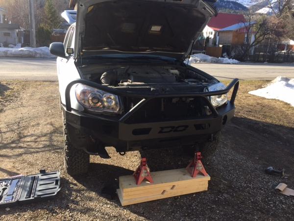 bumper very precariously held in place with some jackstands and the ramps piled on top of eachother.   I had to do the install myself, so I got my wor