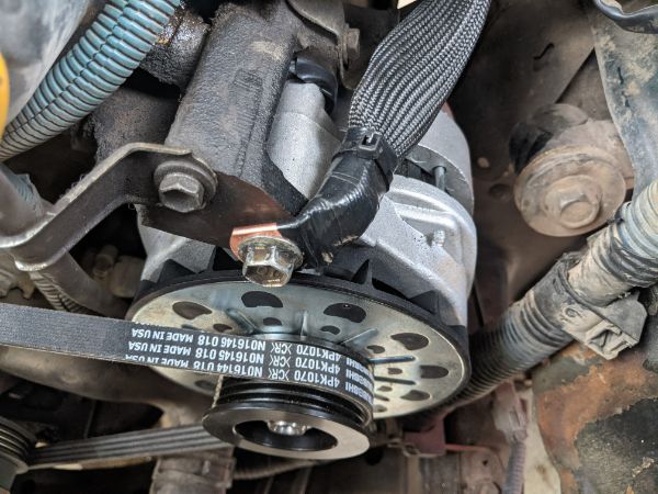 Closeup of the alternator, engine block ground (goes directly to battery negative terminal), and the power steering pump belt used in place of the fac