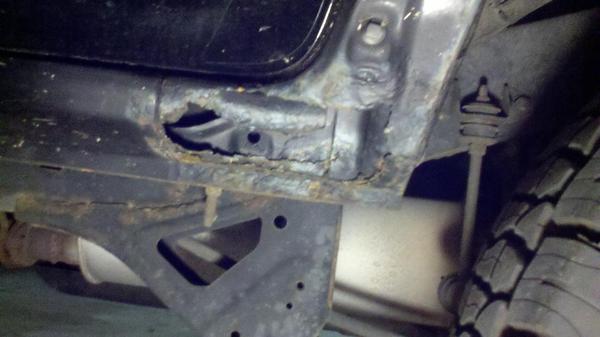 Drivers side below door sill.