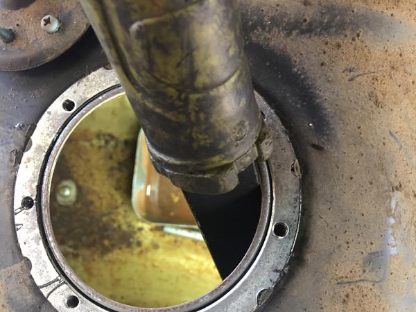 Flashlight looking into the same tank showing the rust at bottom.