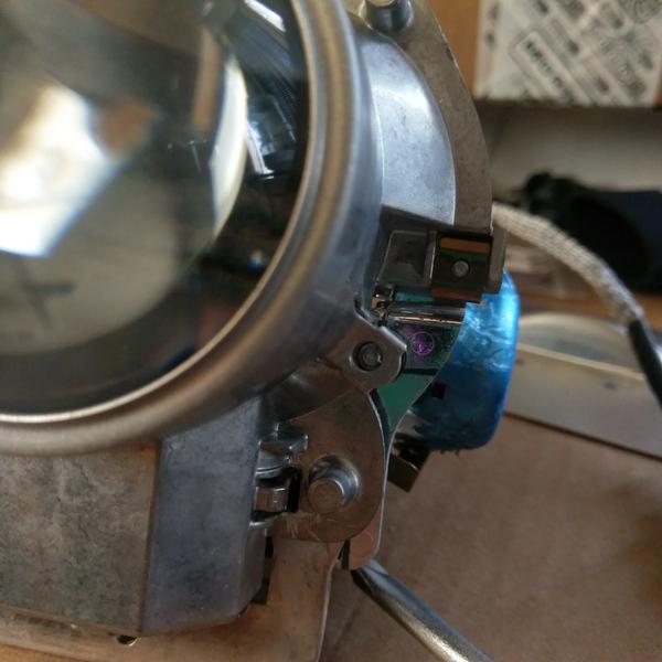 I broke a screw for the projector lens bracket.  You can see it just to the left of the middle of the blue film.  It actually doesn't seem to affect t