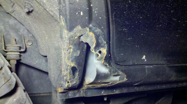 In front of rear pass. wheel well. A piece of plastic was covering this before on both sides. Going to mat & resin.