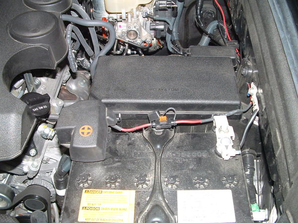 Inline fuse holder fastened to positive battery post and running between battery and fuse box