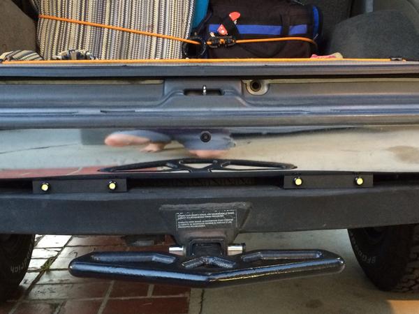 Installed in aluminum rails above the tow hitch.