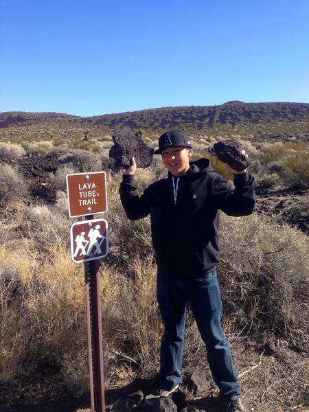 My brother holding some lava rocks at the lava tubes we visited