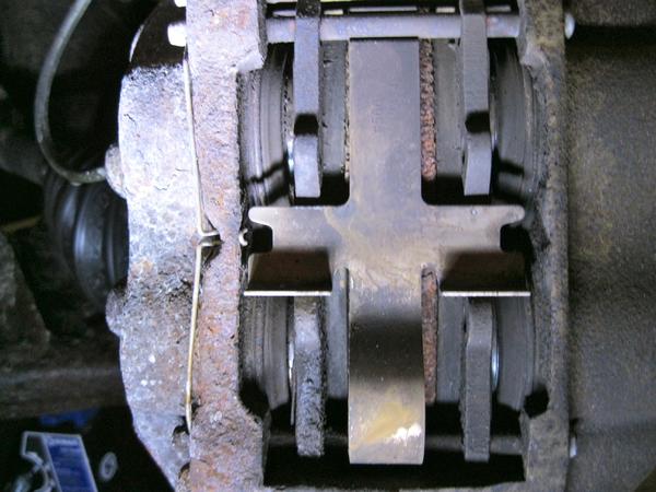 Old rotor and caliper. There was decent meat on the old pads, but upon further inspection they were wearing unevenly and glazing. The rotors were scar