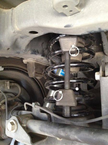 Put spring compressors when car is parked on level surface (remove spare to gain access)