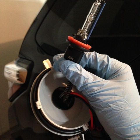 Put your gloves on and "thread" the bulb through the dust cover.  The bulbs have a nice rubber grommet that you will need to finagle into place to sto