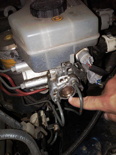 The connector that is just above the knuckle (with the 2, green and white wires). Not the connector directly below the reservoir, but the one below TH