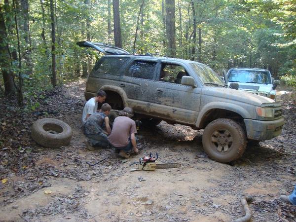 trying to pull out the broken exhaust from rear...had to take off tire for clearance (not sure what the chainsaw was for)